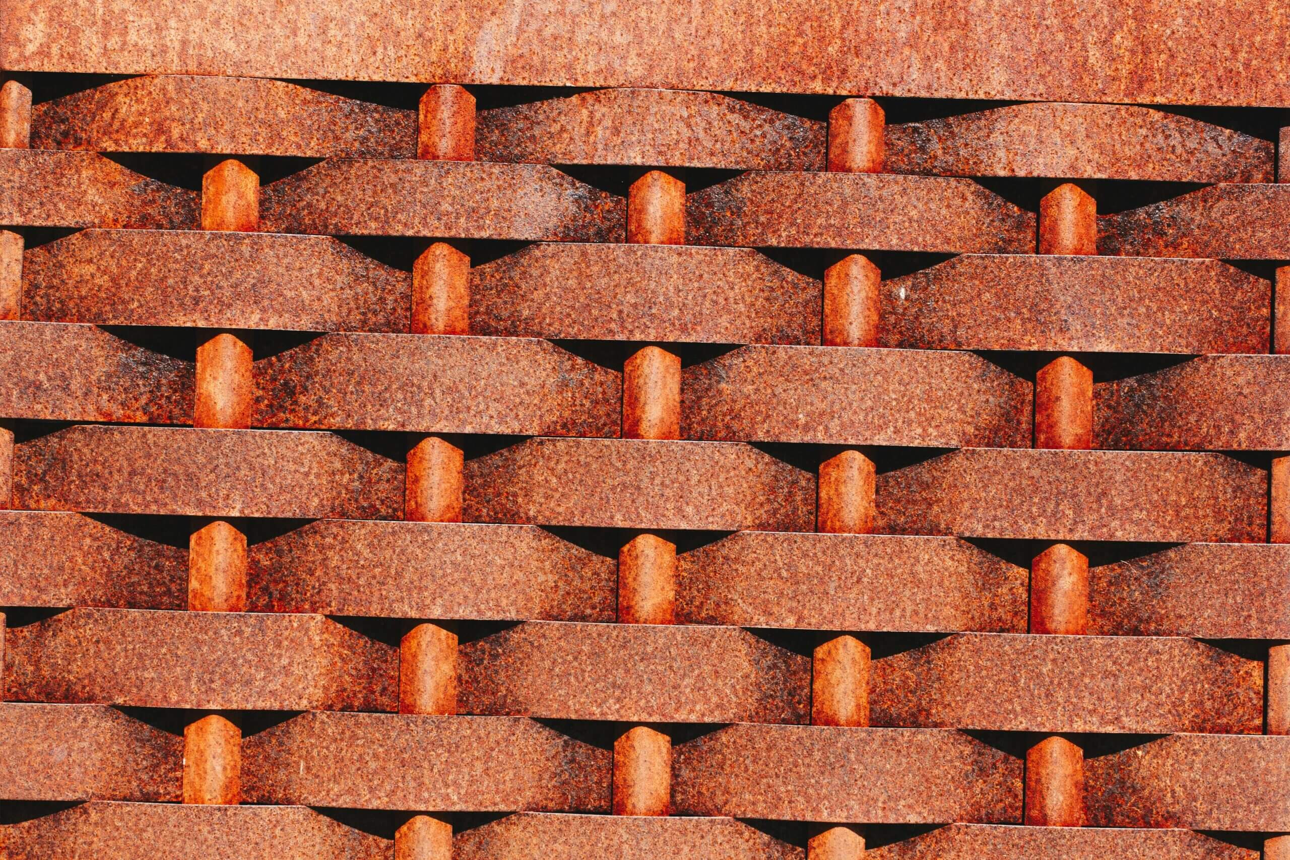 A close-up of a rusty metal wall showcasing intricate patterns and textures, ideal for design projects.